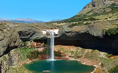 Vista panorámica del Río Agrio serpenteando con sus características costas naranjas hasta desembocar en la gran cascada del Salto del Agrio, en el paisaje volcánico de Caviahue.