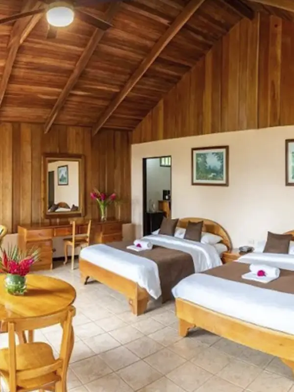 Interior de habitación con dos camas y techos de madera en Hotel Lavas Tacotal.