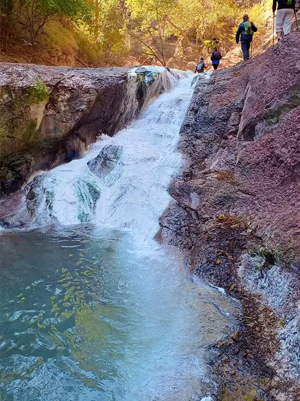 Cascada y poza en las Termas del Río Jordán en Jujuy, con aguas naturalmente tibias en un entorno de montaña.