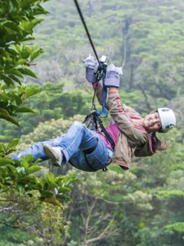 Viajera disfrutando tirolina entre los árboles del Bosque Nuboso de Monteverde en Costa Rica con Vivak Aventuras