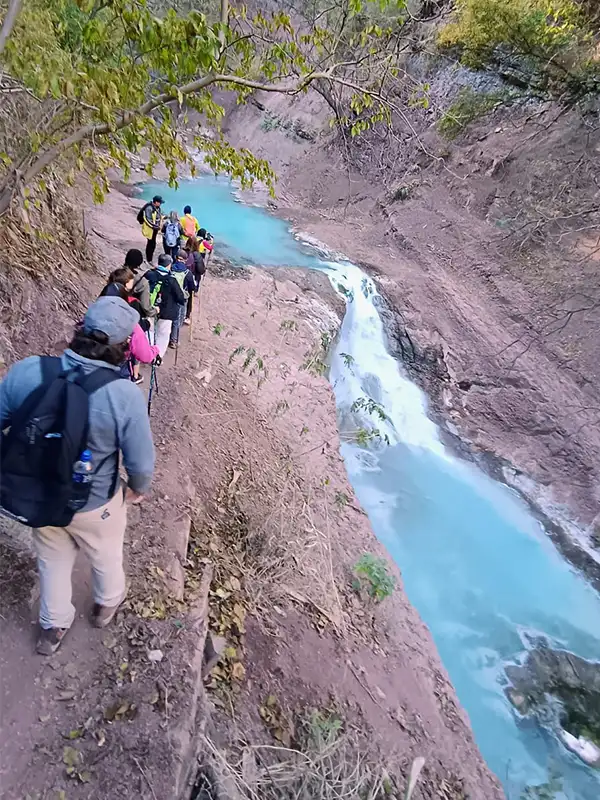 Viajeros disfrutando las aguas turquesa de las Termas del Río Jordán en Jujuy.