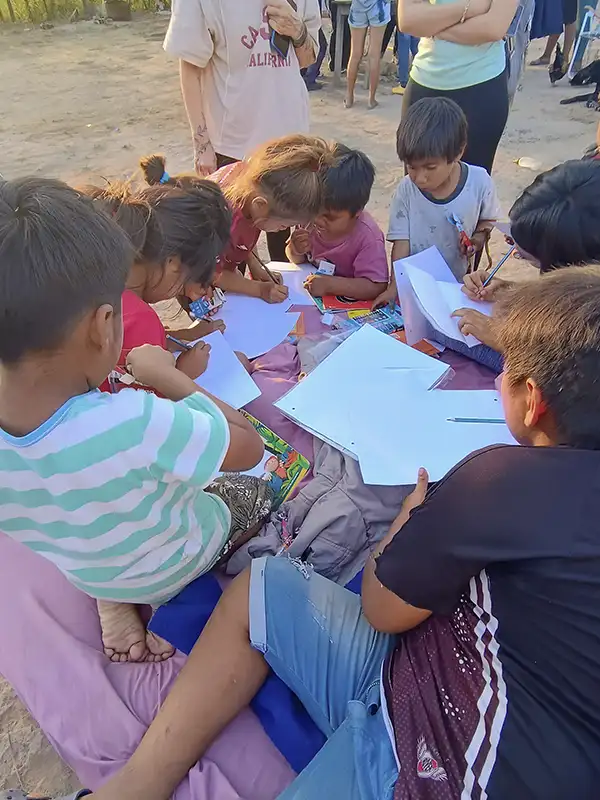 Niños de la comunidad pilagá dibujando con los útiles escolares que llevamos como donación en cada viaje a Bañado La Estrella, Formosa.