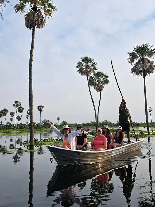 Grupo de viajeras de Vivak Aventuras navegando entre palmeras carandillo en los canales del Bañado La Estrella, Formosa, durante el safari náutico.