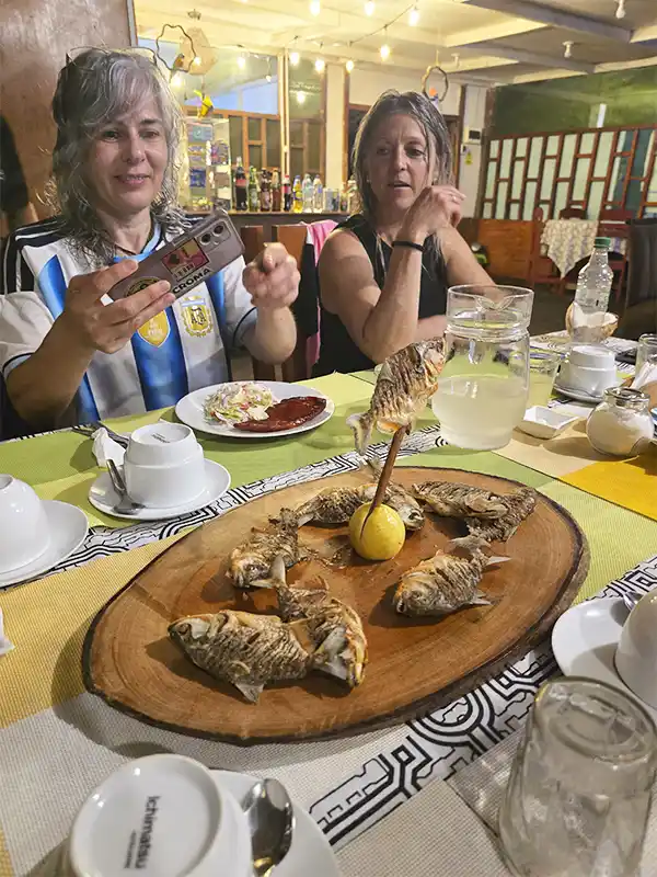 Viajeras disfrutando de una cena con pescado amazónico típico en un restaurante de Iquitos, Perú.