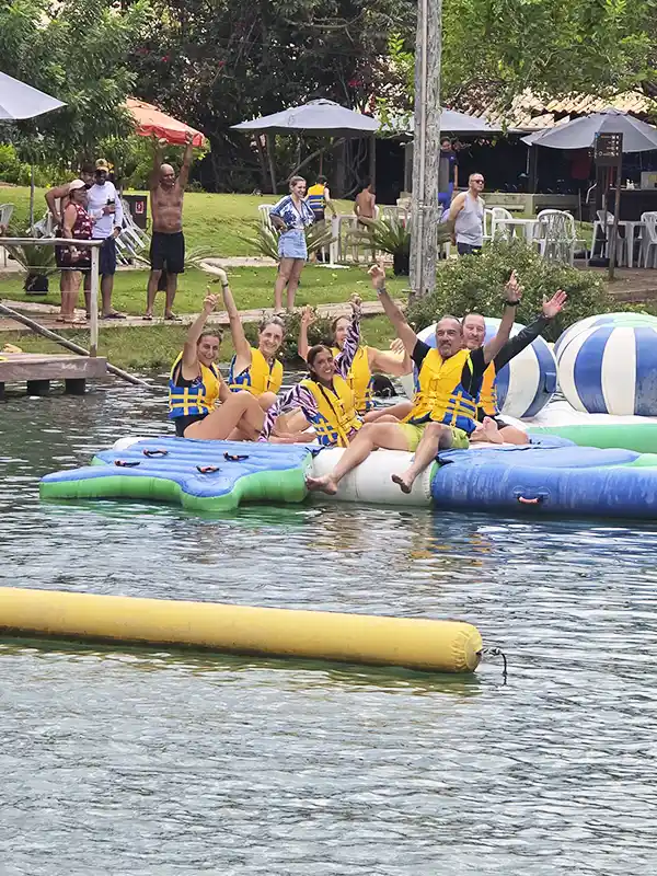 Grupo de viajeros disfrutando de inflables y juegos acuáticos en el parque de Nascente Azul, Bonito