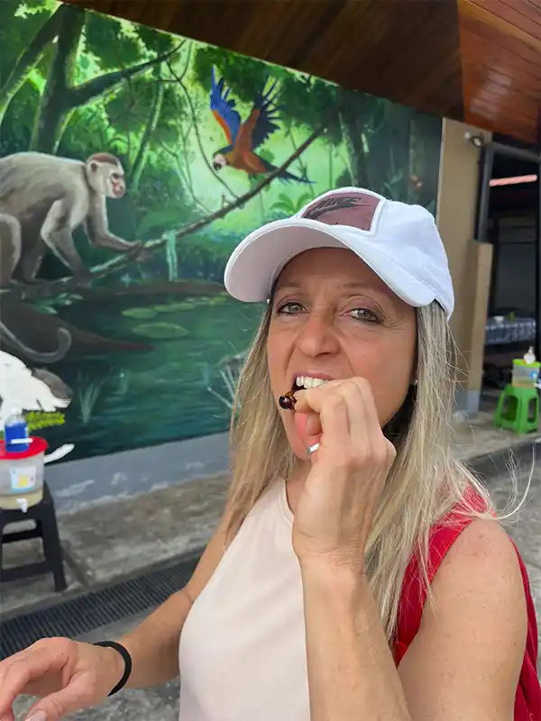 Viajera probando suri, gusano típico de la gastronomía amazónica, durante una degustación en Iquitos, Perú.