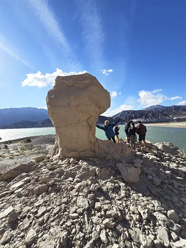 Viajeros de Vivak Aventuras junto a una formación rocosa en el Dique Cuesta del Viento, San Juan