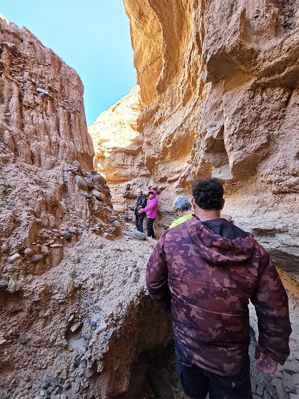 Grupo de viajeros recorriendo un laberinto de arcilla entre paredes rocosas en Pasleam