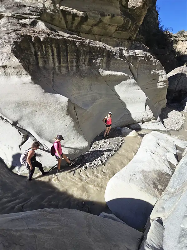 Grupo de viajeros explorando el cañón de paredes claras en Pasleam, San Juan