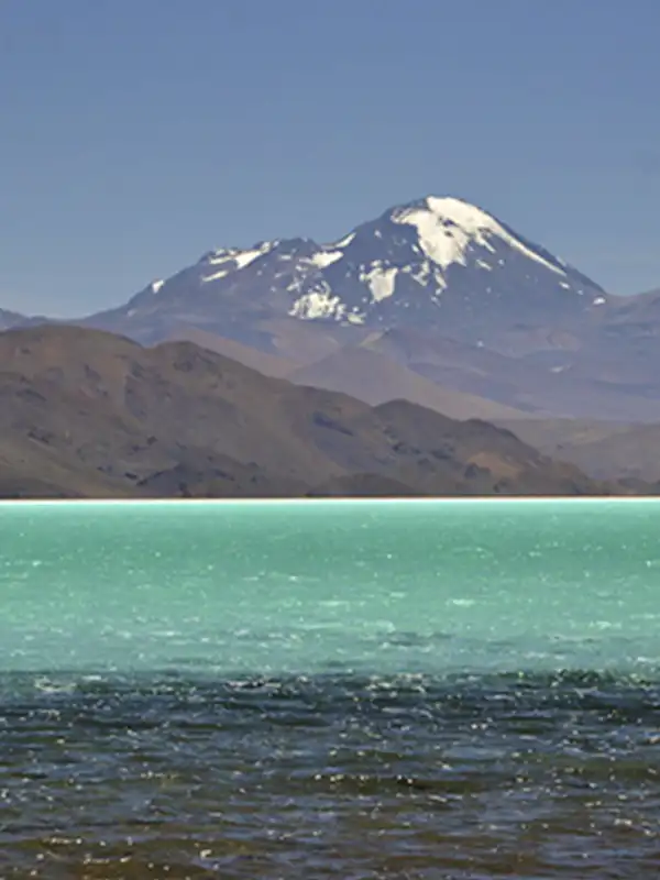 Laguna turquesa con montañas nevadas en el Balcón del Pissis, Catamarca.